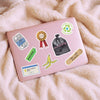 Pink laptop with various stickers on a fluffy beige surface