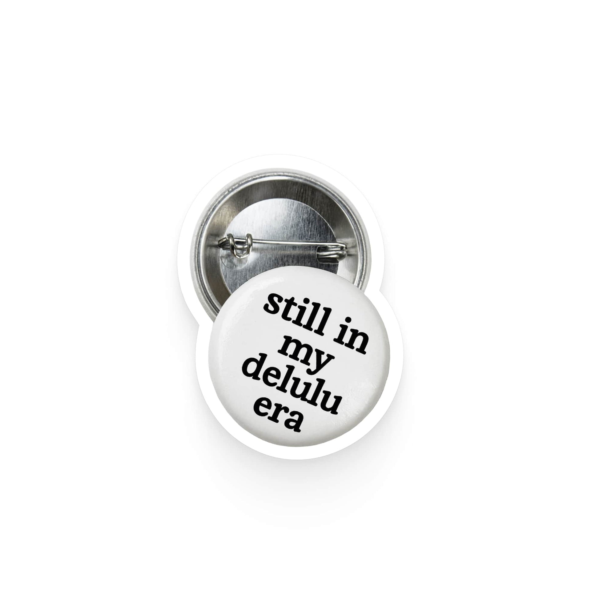 Button badge with text 'still in my delulu era' on a white background